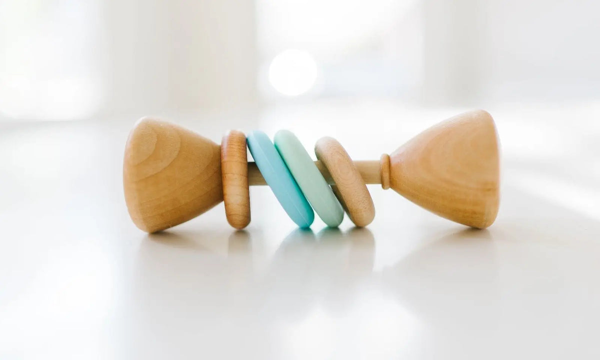 Bannor Toys Color Block Classic Baby Rattle, showing wooden body and colored silicone rings