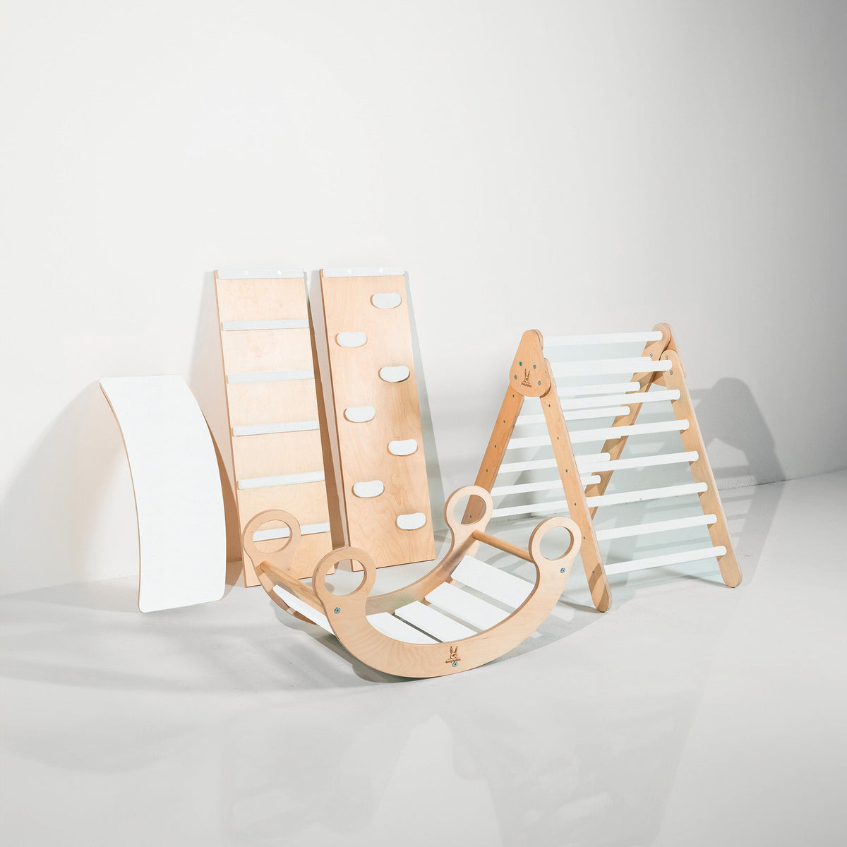 White-accent climbing triangle, two ramps, curved wobble board and rocker displayed together.
