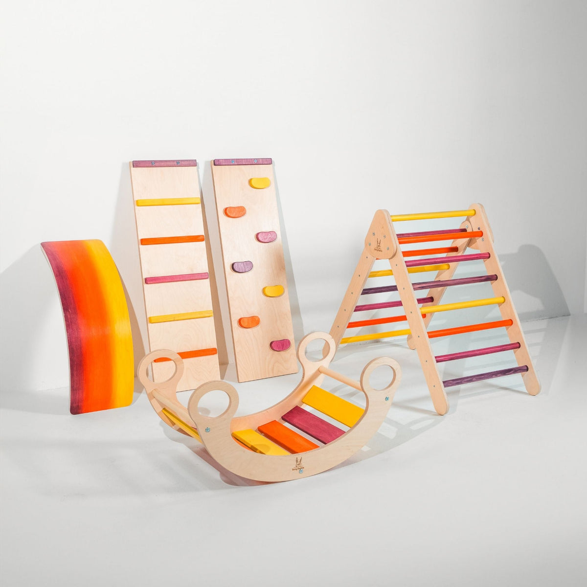 Pink, purple, orange and yellow triangle, two ramps, curved wobble board and rocker displayed together.