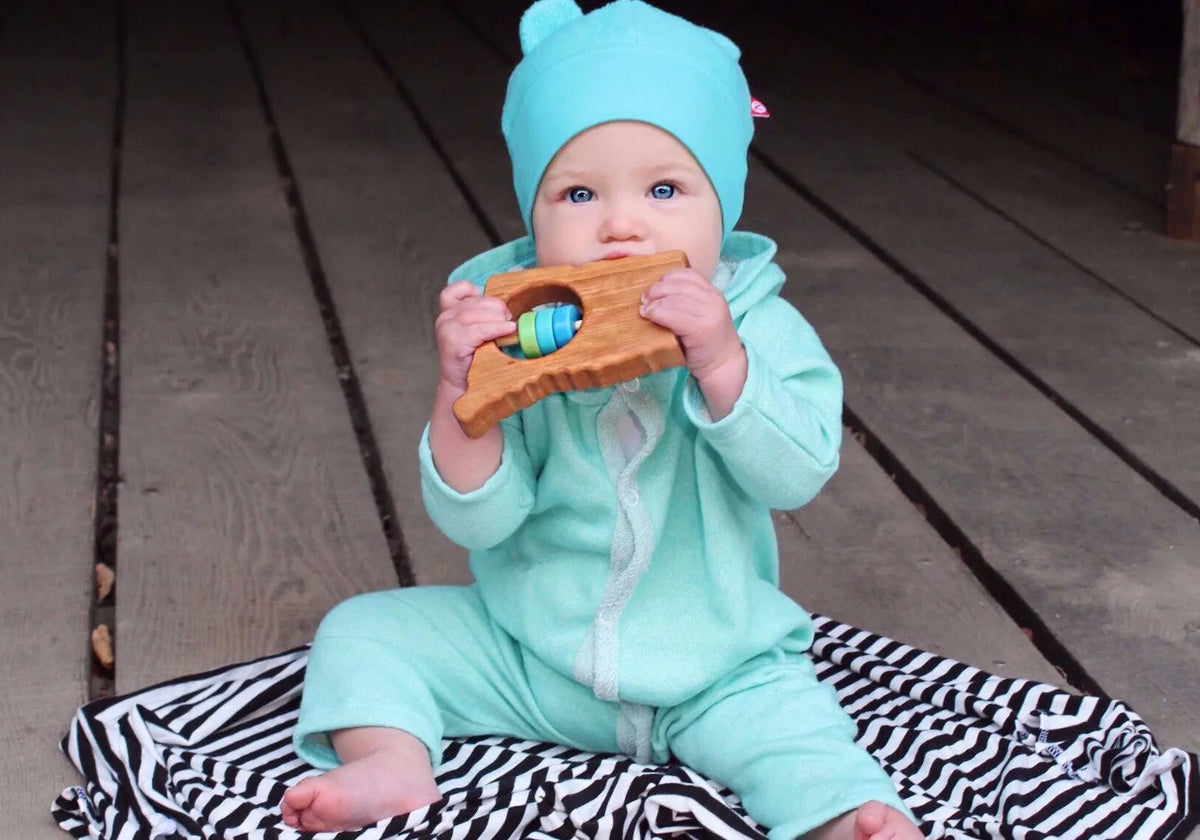 Lifestyle photo showing a wooden state rattle with a child