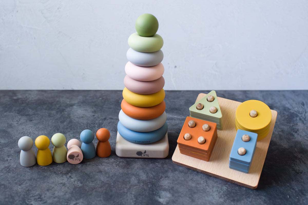 Sensory Starter Kit with six silicone peg dolls, an assembled ring stacker, and a shape puzzle.