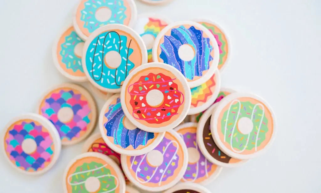 Close-up of round wooden tiles printed with colorful donut designs
