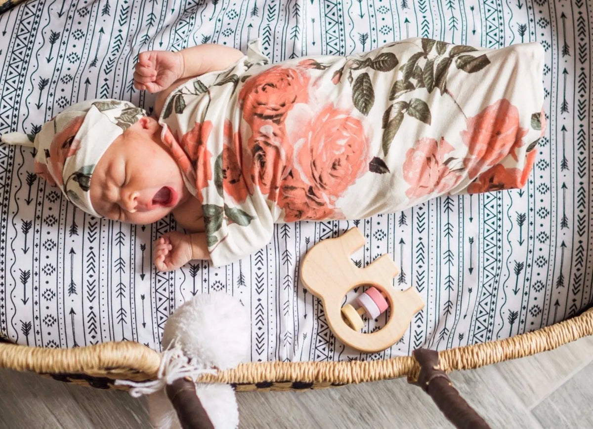 Lifestyle photo showing a wooden baby rattle with a child