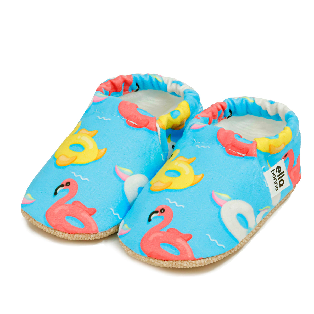 Pair of blue slip-on baby moccasins with colorful duck, swan and flamingo pool-float print on a white background.