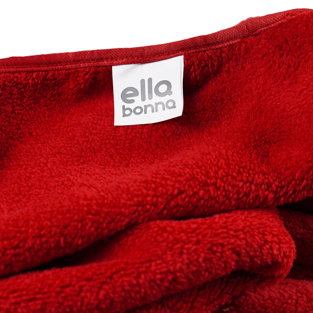 Red fleece blanket edge and Ella Bonna label close-up.