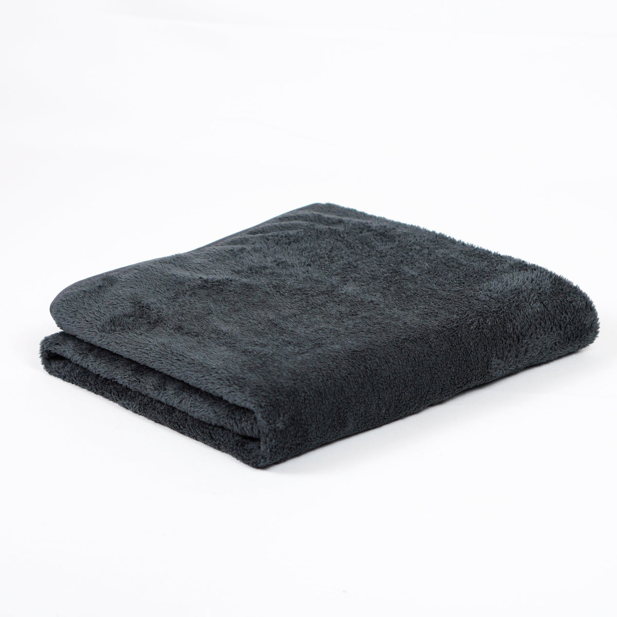 Charcoal fleece blanket folded on white.
