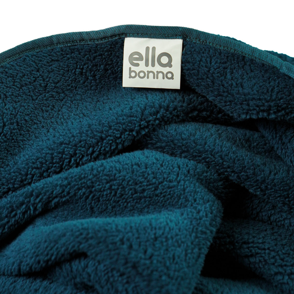 Teal fleece blanket edge and Ella Bonna label close-up.