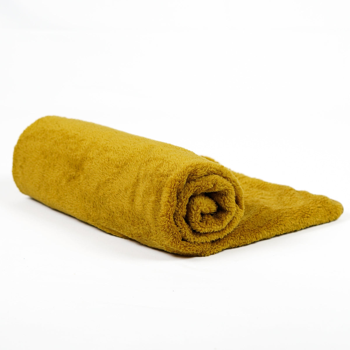 Mustard yellow fleece blanket rolled on white.