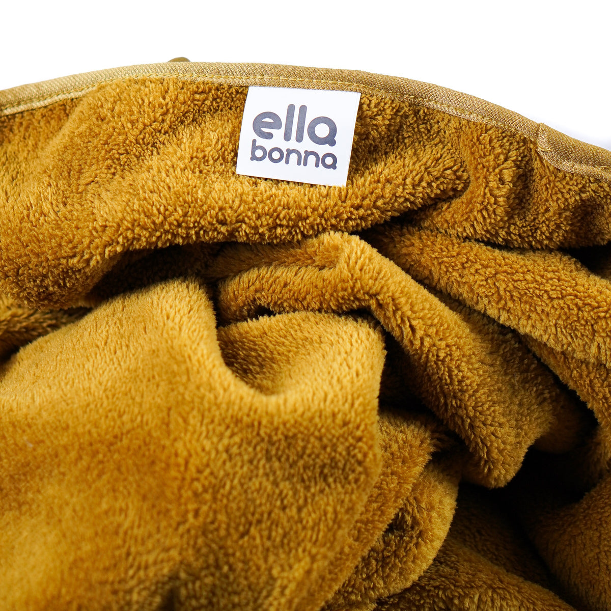 Mustard yellow fleece blanket edge and Ella Bonna label close-up.