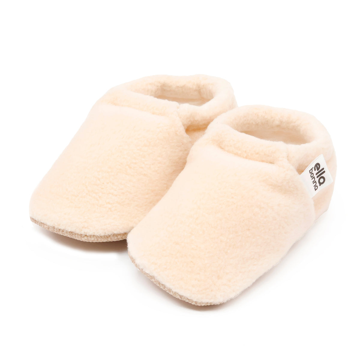 Pair of cream fleece slip-on baby moccasins with tan soles on a white background.