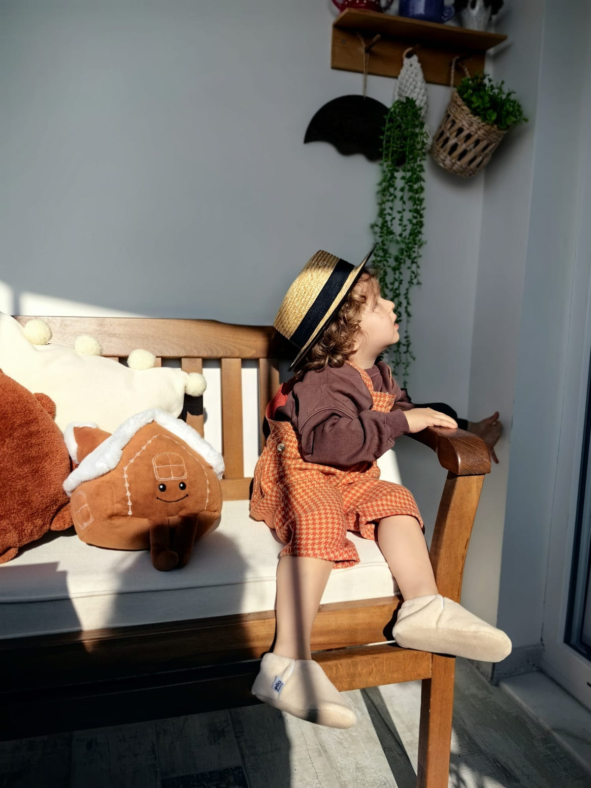 Child seated on a chair wearing cream fleece moccasins.