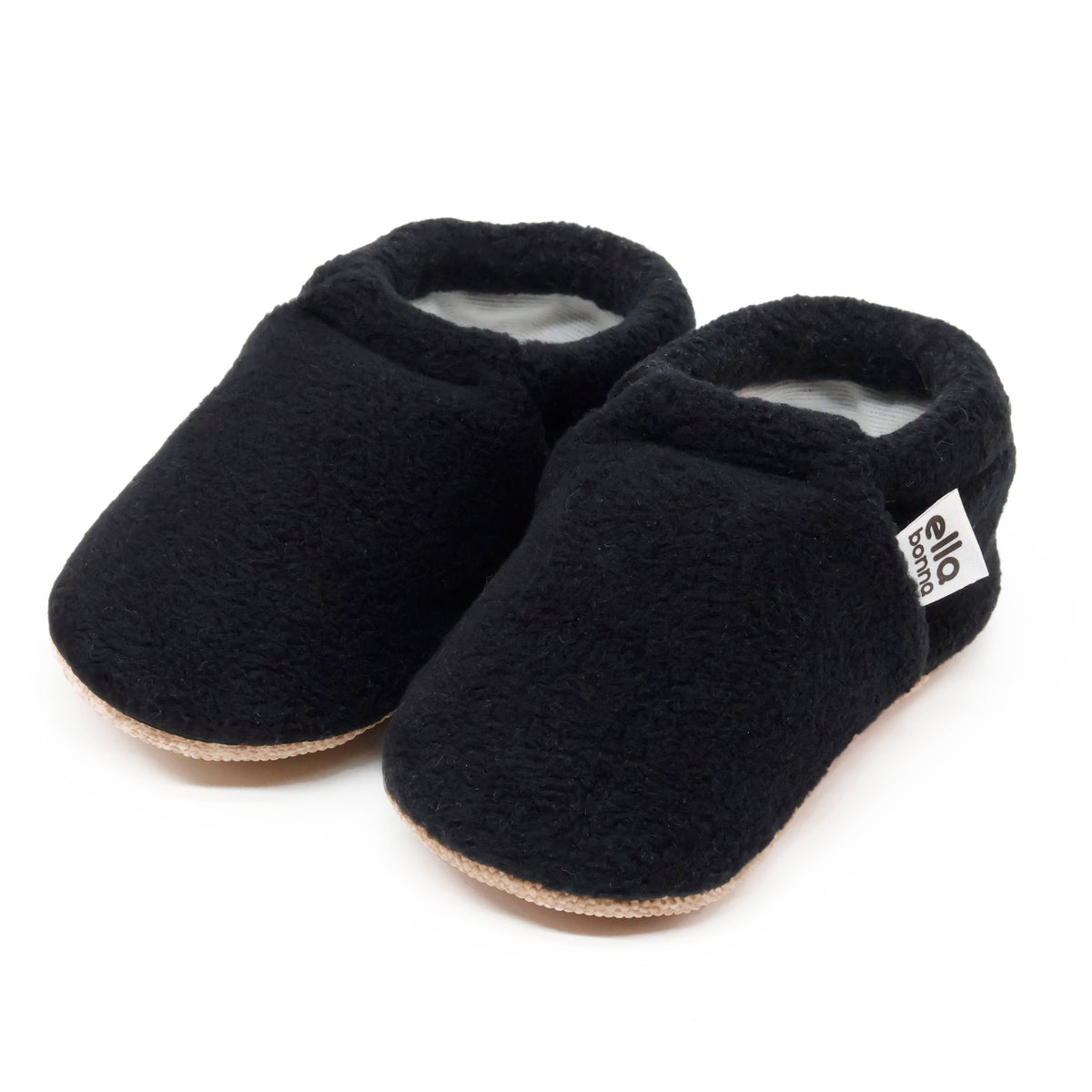 Pair of black fleece slip-on baby moccasins with tan soles on a white background.