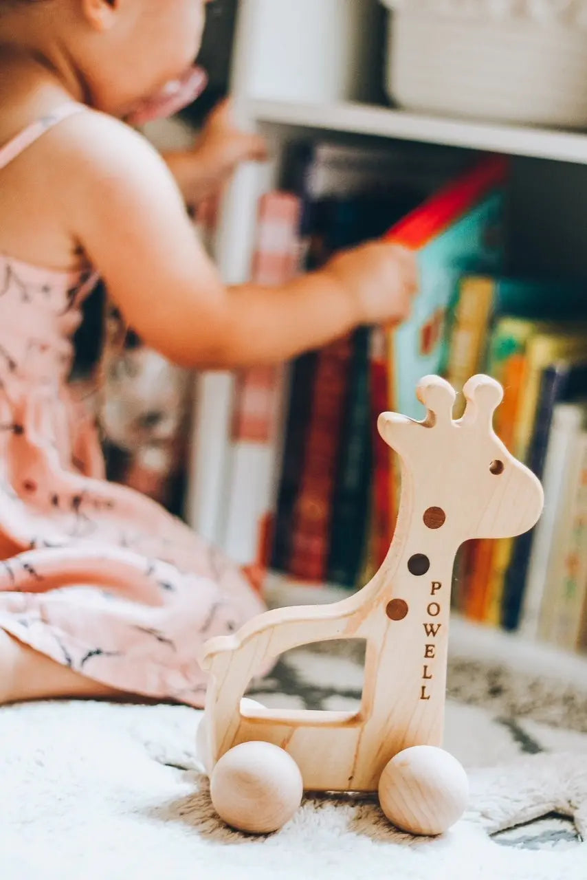 Lifestyle photo showing a wooden push toy with a child