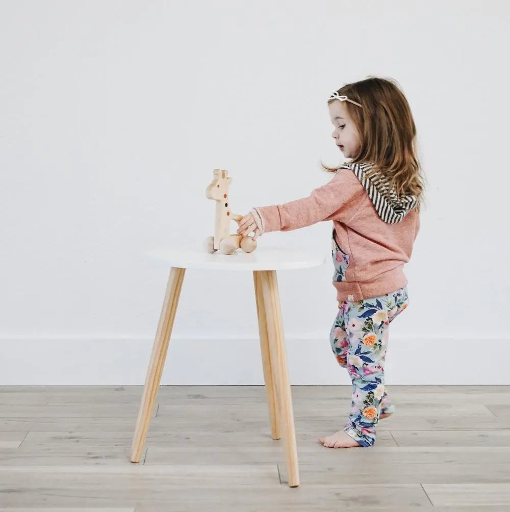Lifestyle photo showing a wooden push toy with a child
