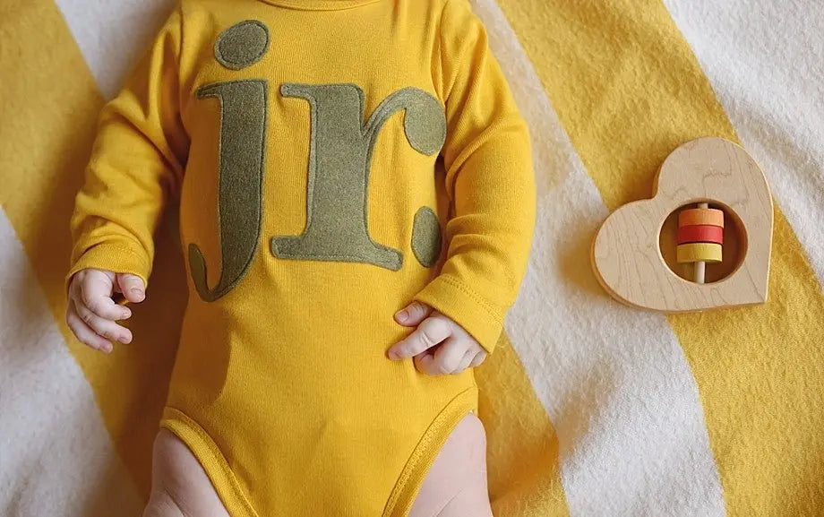 Lifestyle photo showing a wooden baby rattle with a child