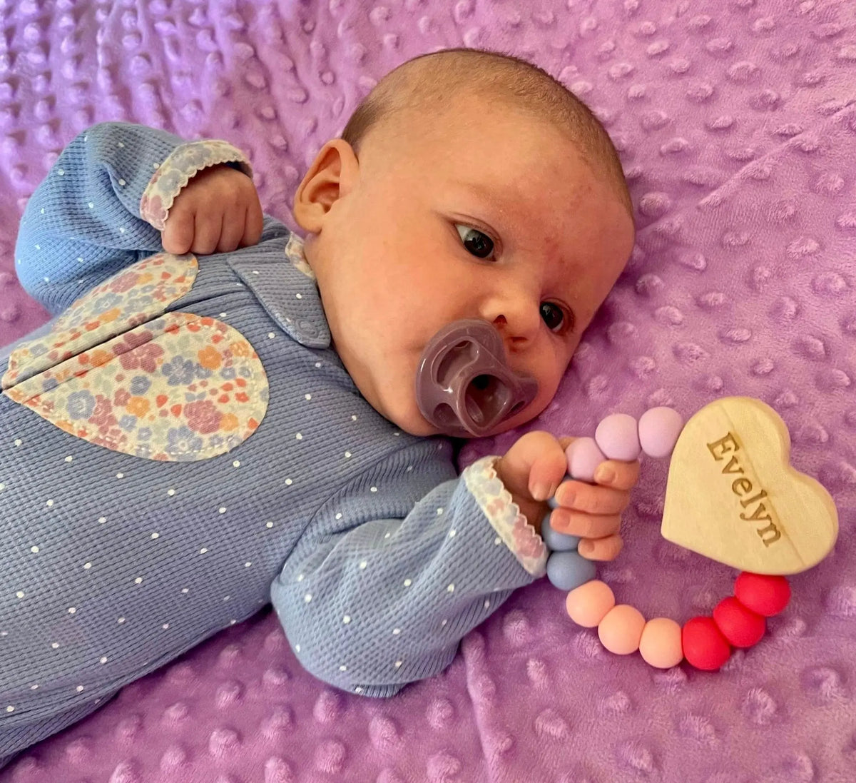 Lifestyle photo showing a wood and silicone teether with a child