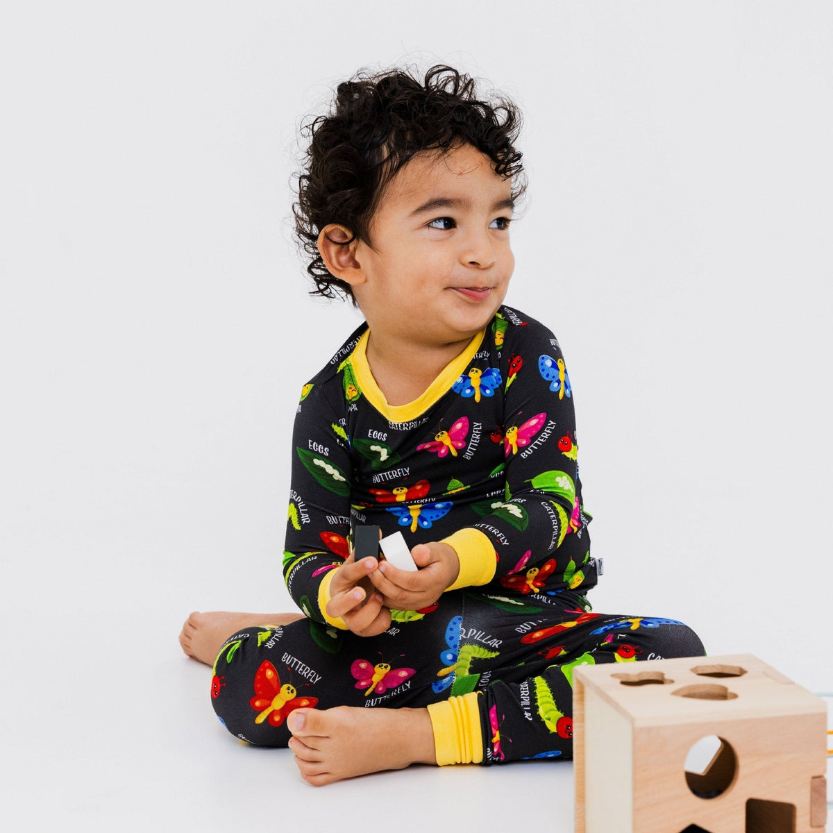 Child seated with toys while wearing Bam & Stitch It's Morphing Time! Long Sleeve Pajamas.