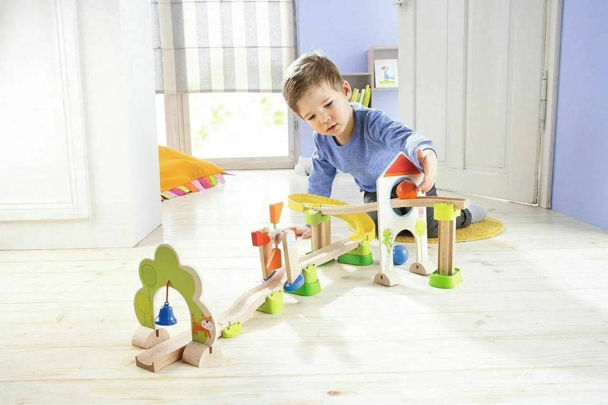 A child playing with the full Kullerbu Windmill track, including the arch, yellow curve and tree bell