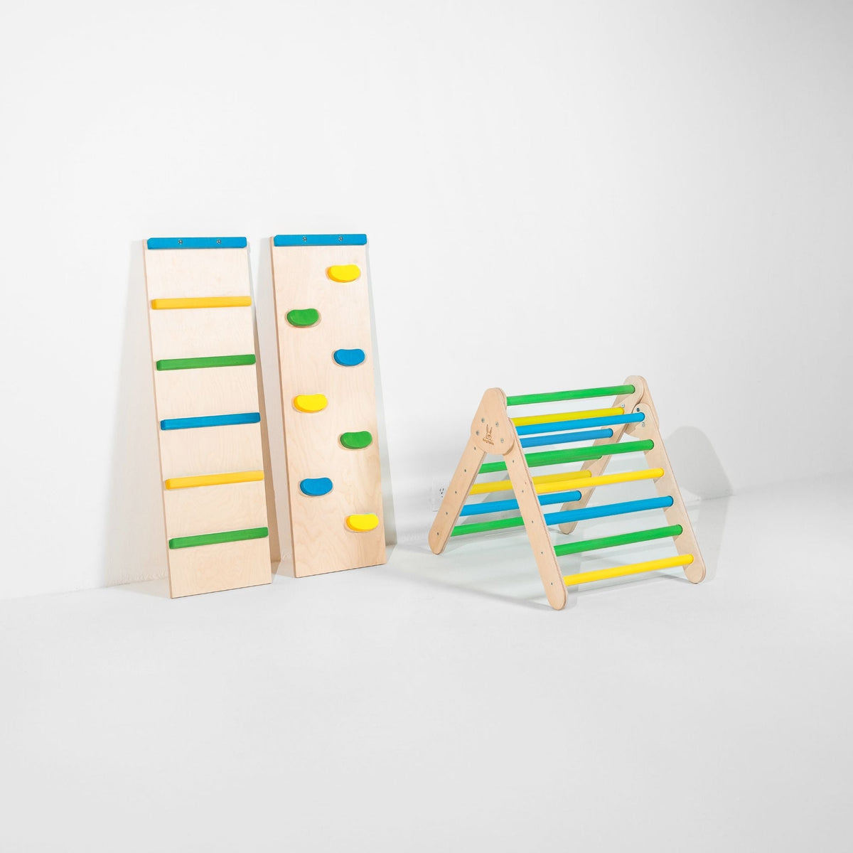 Small blue, green and yellow climbing triangle beside two upright ramps.