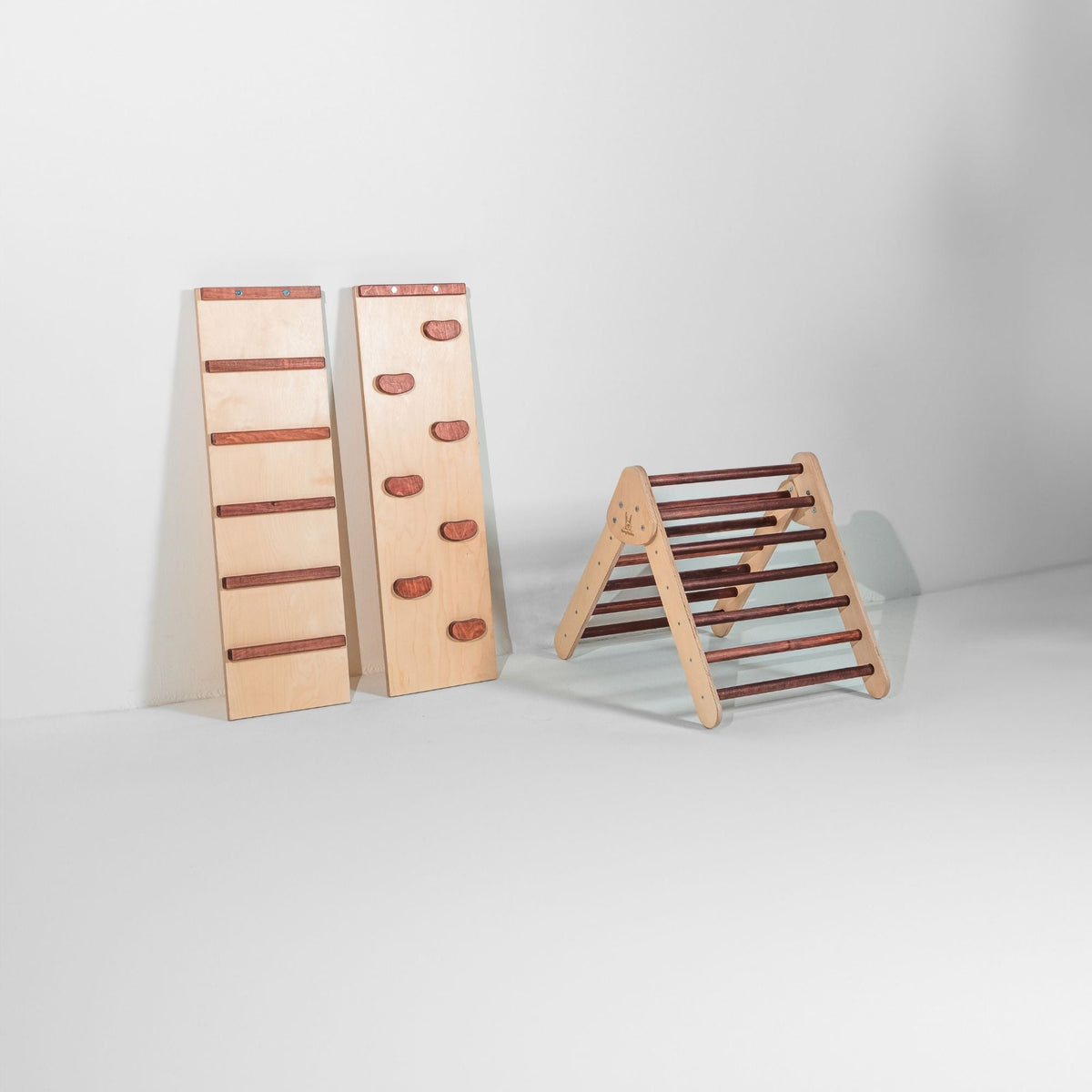 Small reddish-brown-rung climbing triangle beside two upright ramps.