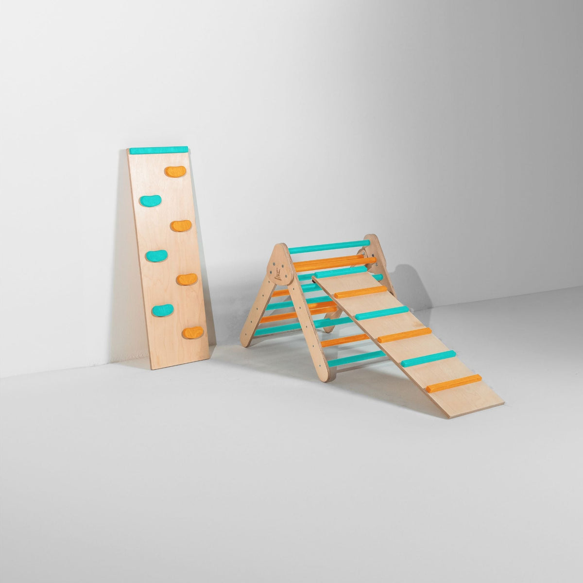 Small teal and orange triangle with attached ladder ramp and a climbing-hold ramp beside it.