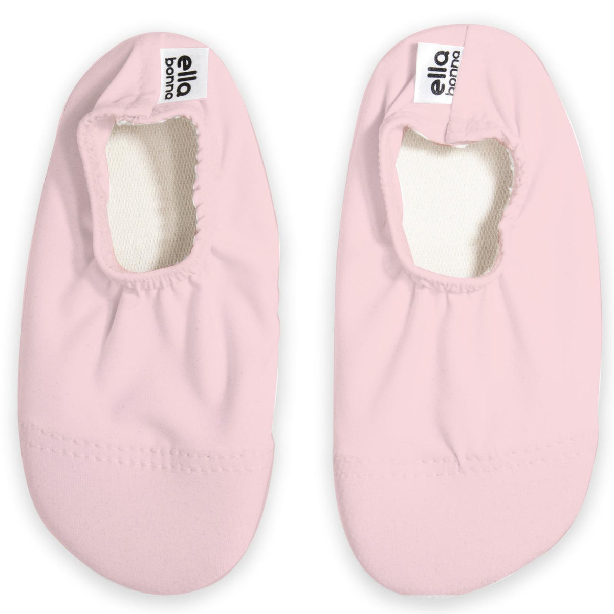 Top view of a pair of pale pink slip-on water shoes with cream lining on a white background.