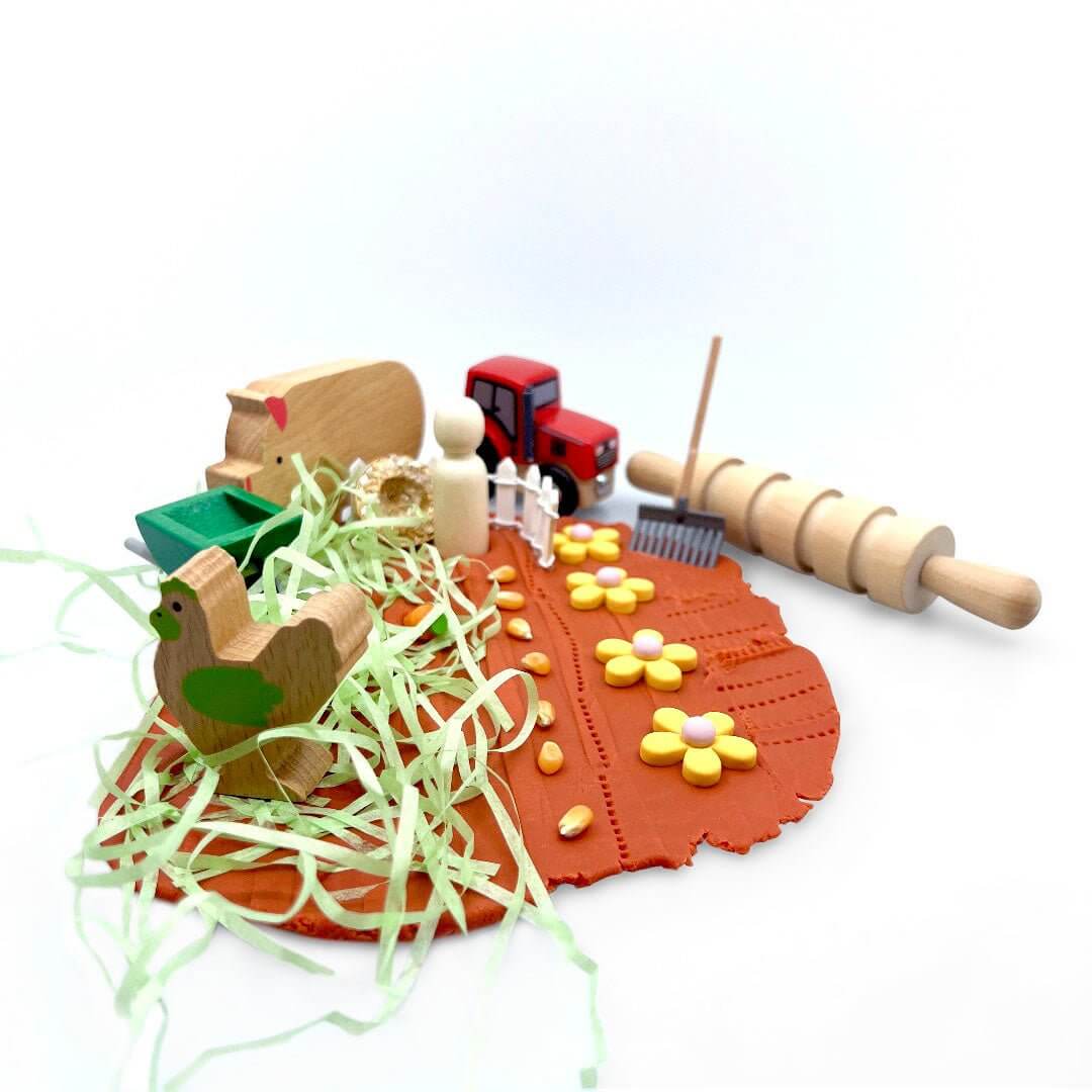 Once Upon a Farm playdough scene with animals, tractor, wheelbarrow and rolling pin