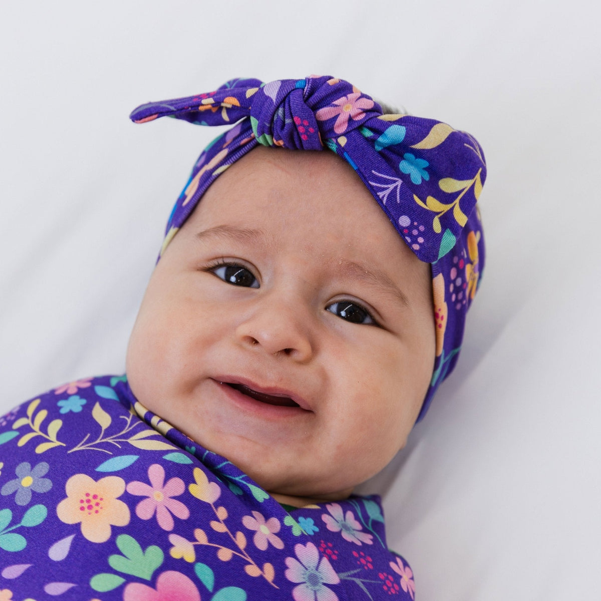 Close-up of a baby wearing Bam & Stitch Orchid Gardens Bow Headband.