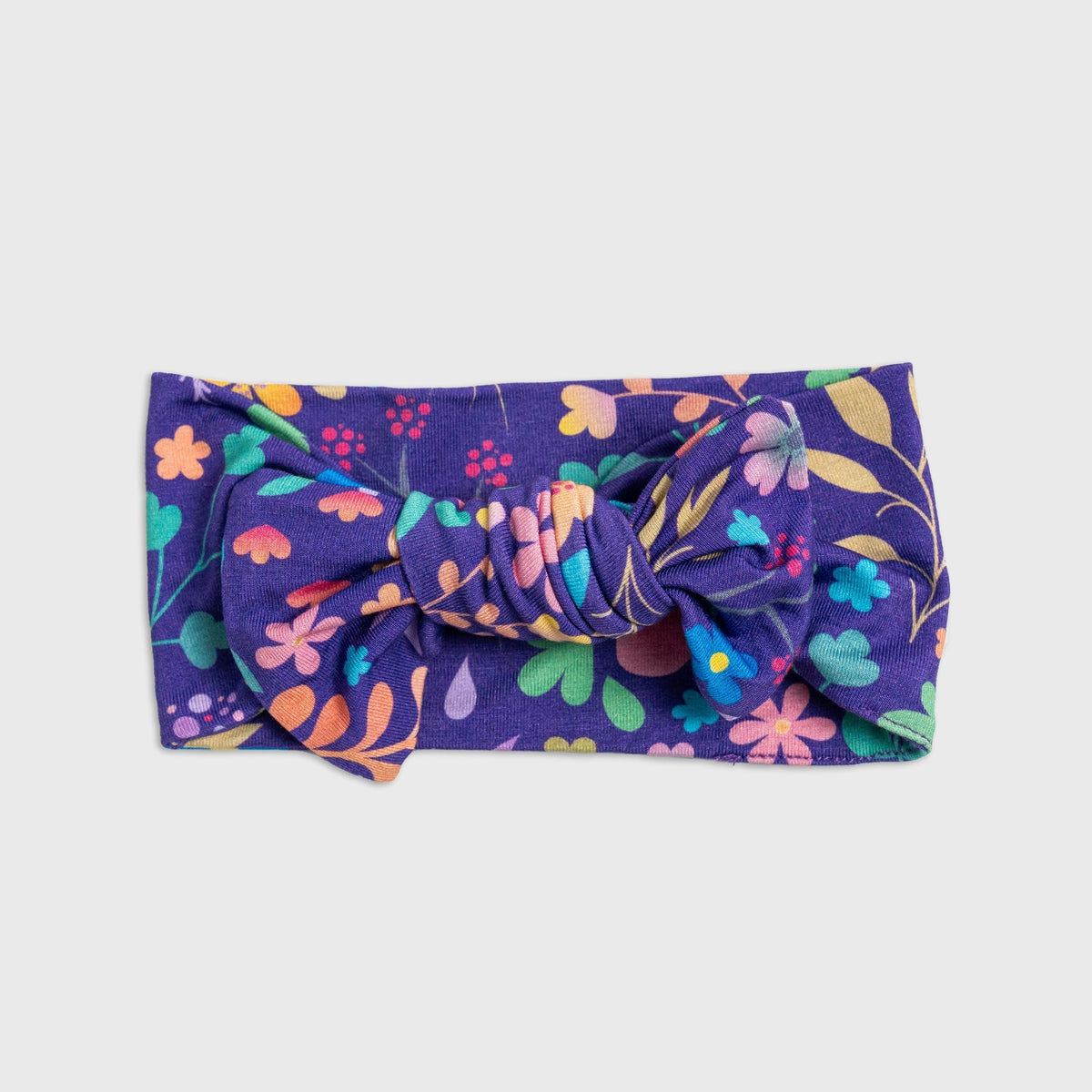 Flat lay of Bam & Stitch Orchid Gardens Bow Headband, showing the bow and fabric band.