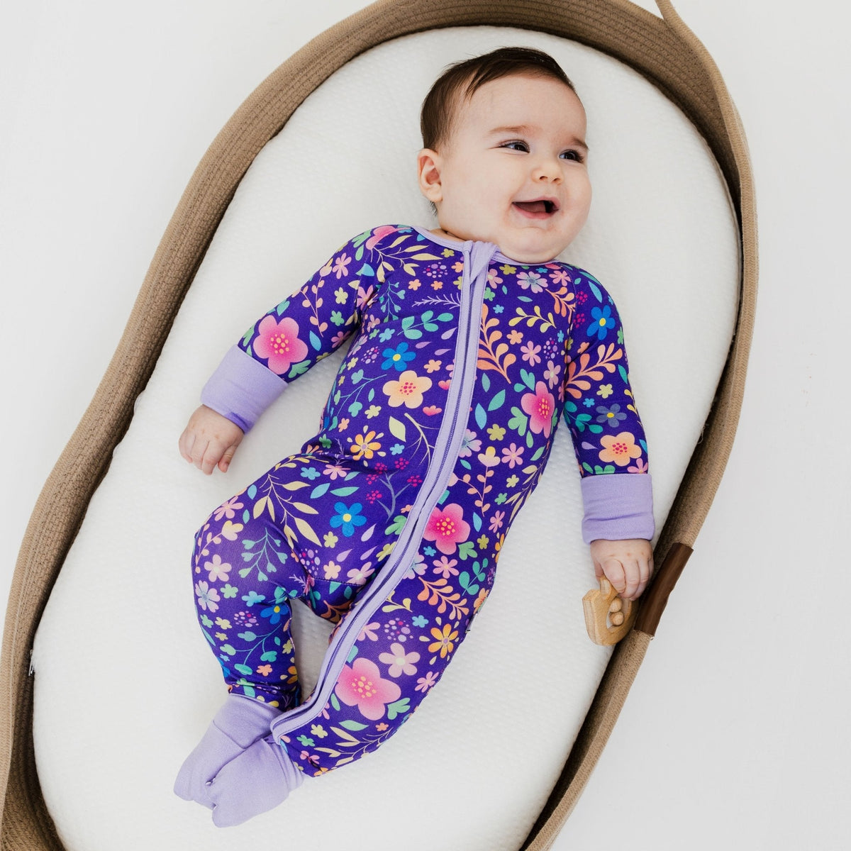 Baby lying on their back in Bam & Stitch Orchid Gardens Convertible Romper.