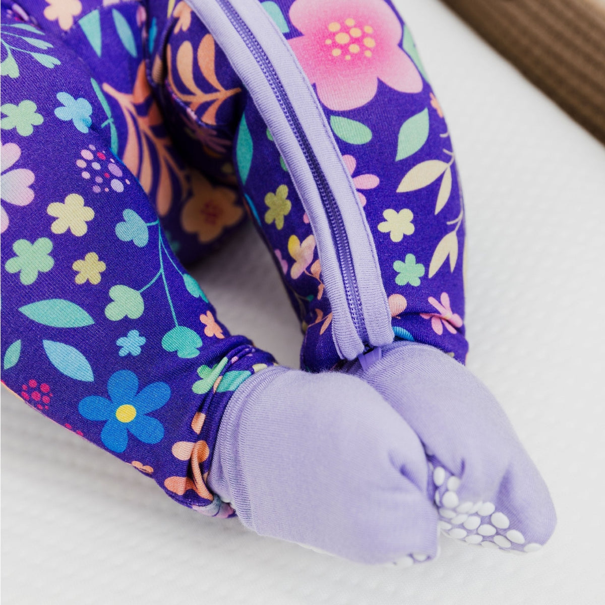 Close-up of the covered feet on Bam & Stitch Orchid Gardens Convertible Romper.