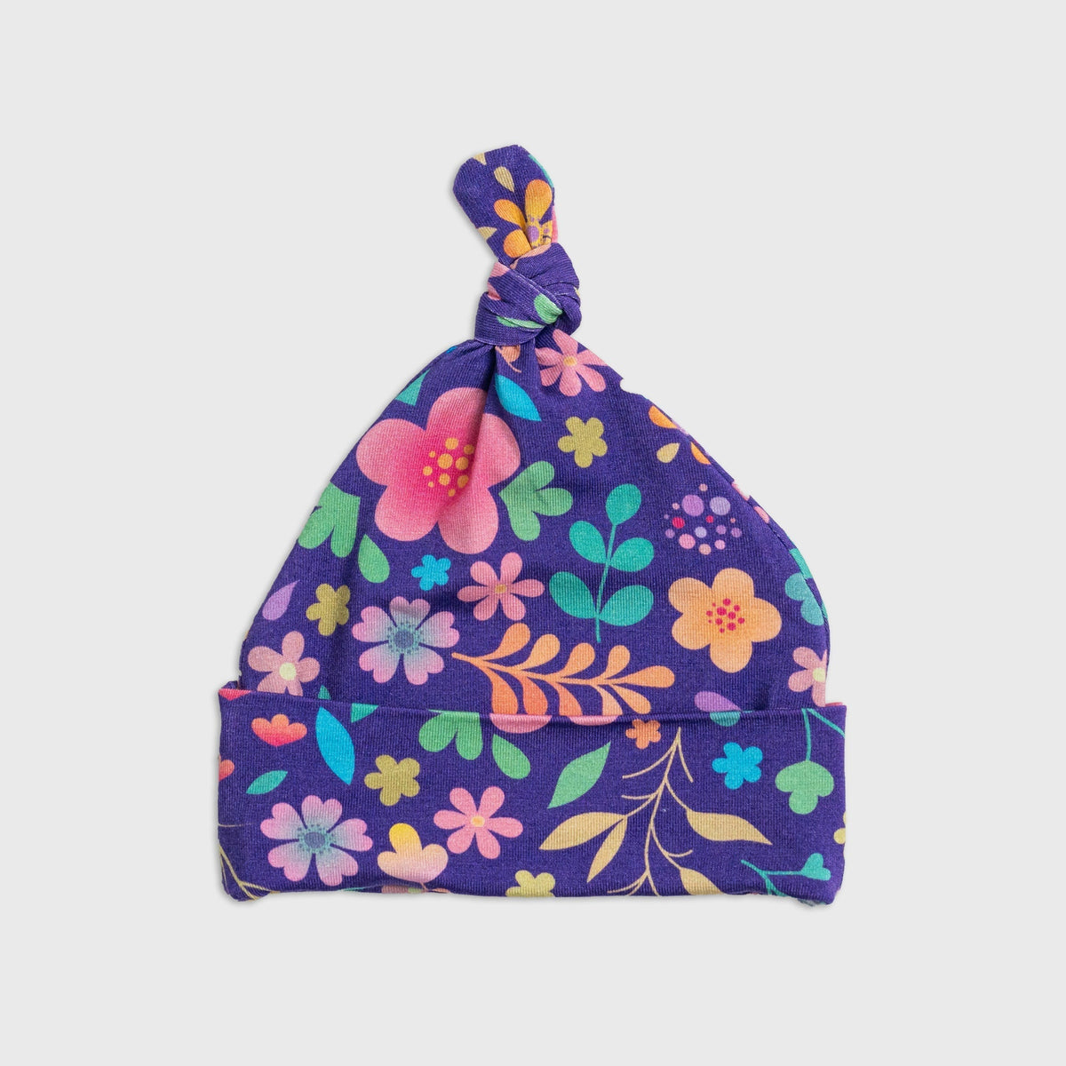 Flat lay of Bam & Stitch Orchid Gardens Hat, showing the top knot and folded brim.