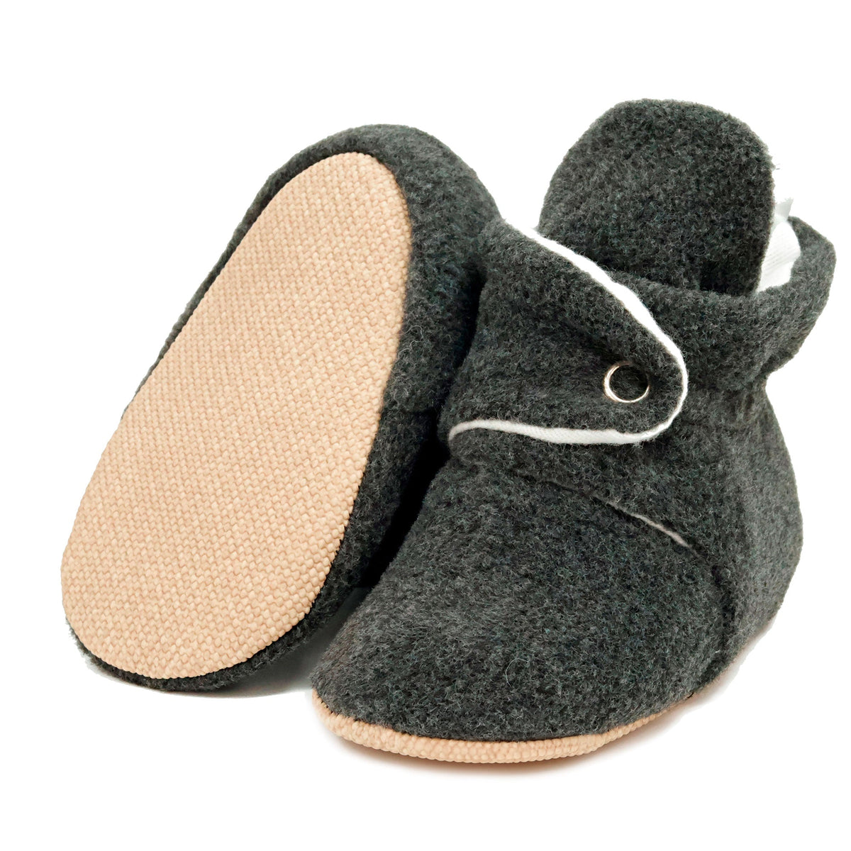 Charcoal fleece-texture baby booties with snap straps and tan soles, with one sole facing the camera on a white background.