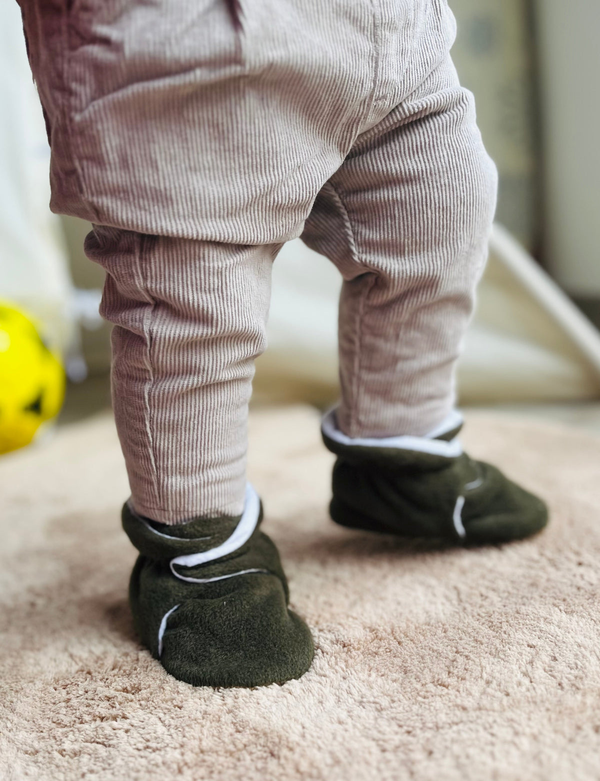 Rear close-up of olive booties worn while standing.