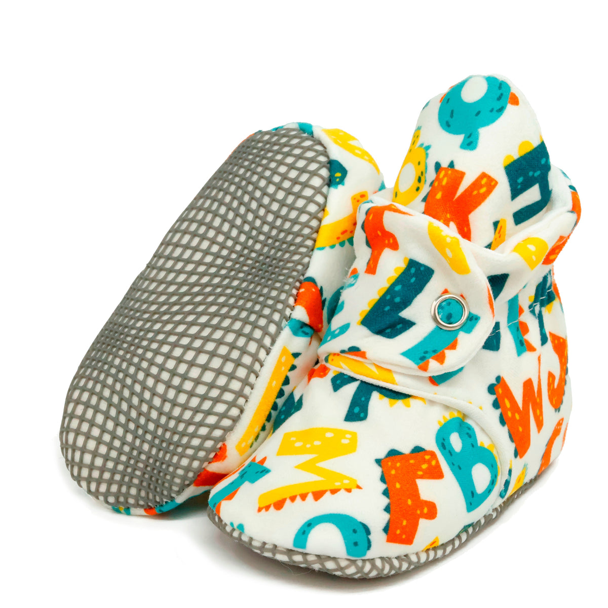 White fabric baby booties with colorful alphabet print and snap straps, with one sole facing the camera on a white background.