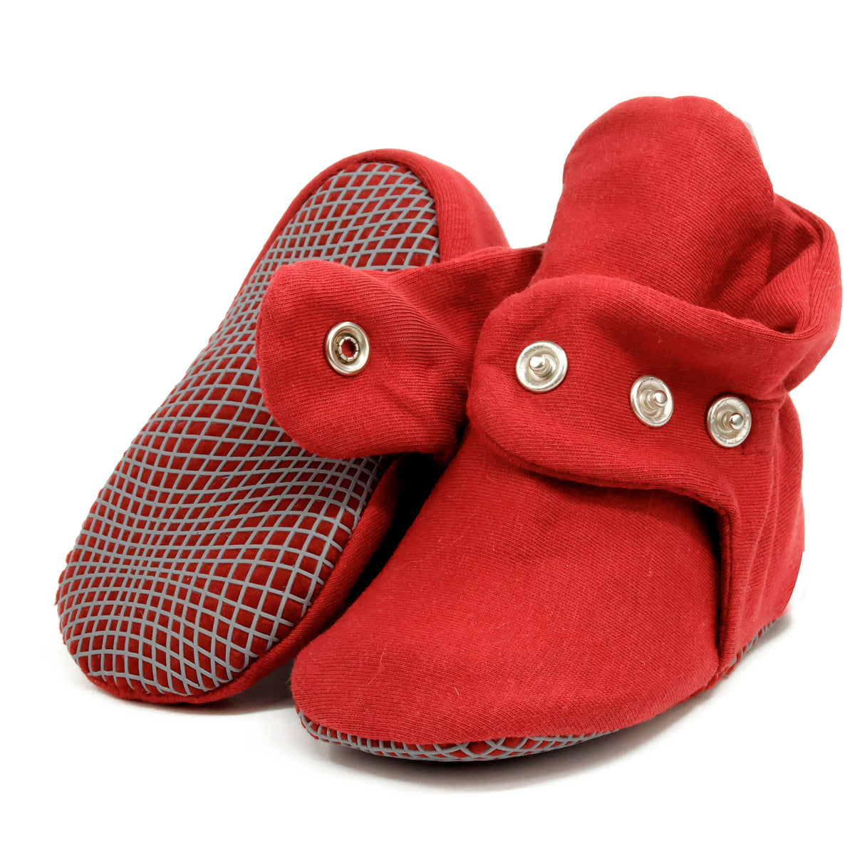Burgundy fabric baby booties with snap straps and gray grip soles, showing one sole and an open snap strap on white.