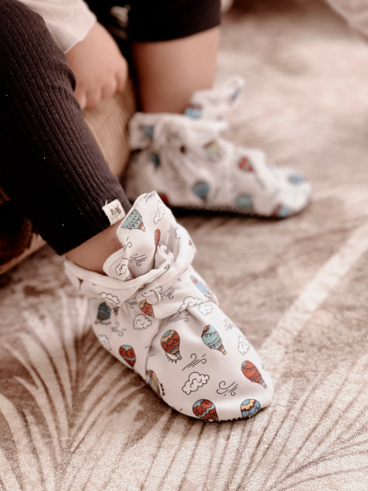 Close-up of balloon-print booties worn with dark trousers.