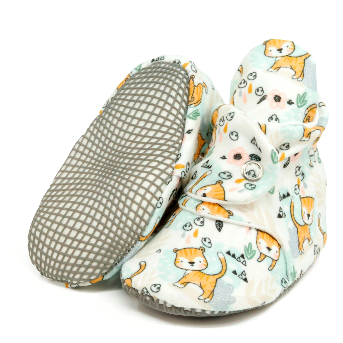 Cream baby booties with small yellow cats and snap straps, with one sole facing the camera on a white background.