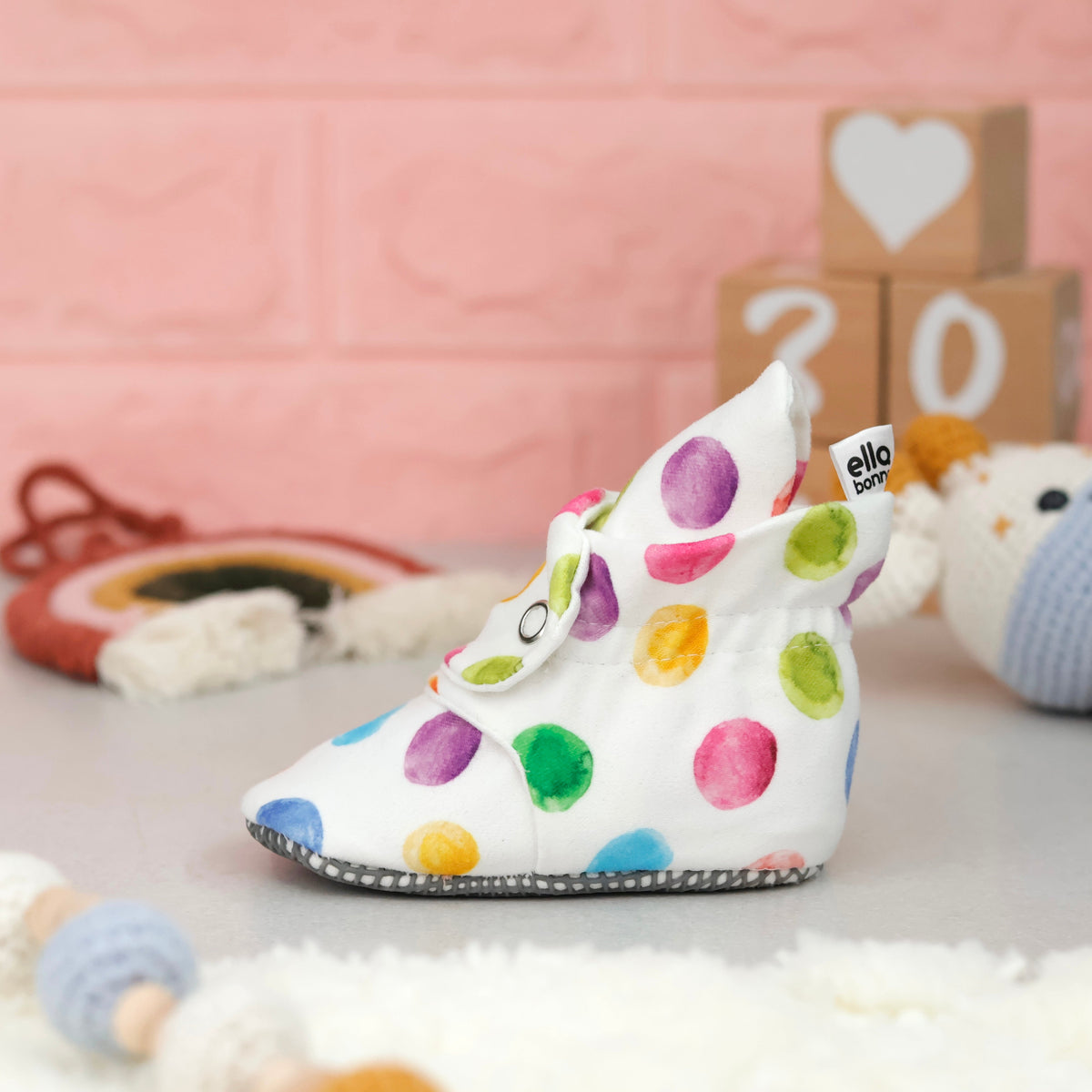 Single dot-print bootie on a tabletop, side view.