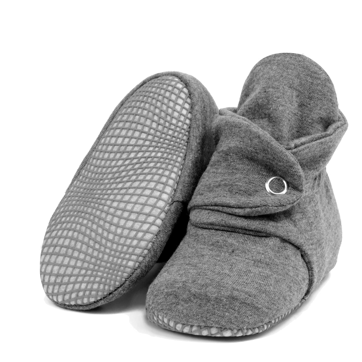 Dark gray fabric baby booties with snap straps and gray grip soles, with one sole facing the camera on a white background.