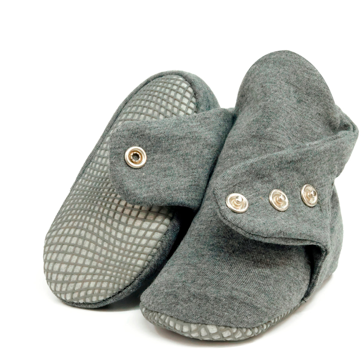 Dark gray fabric baby booties with snap straps and gray grip soles, showing one sole and an open snap strap on white.