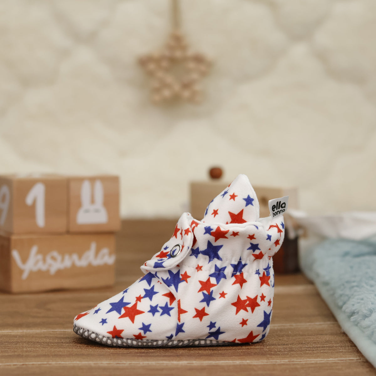 Single star-print bootie on a tabletop, wider side view.