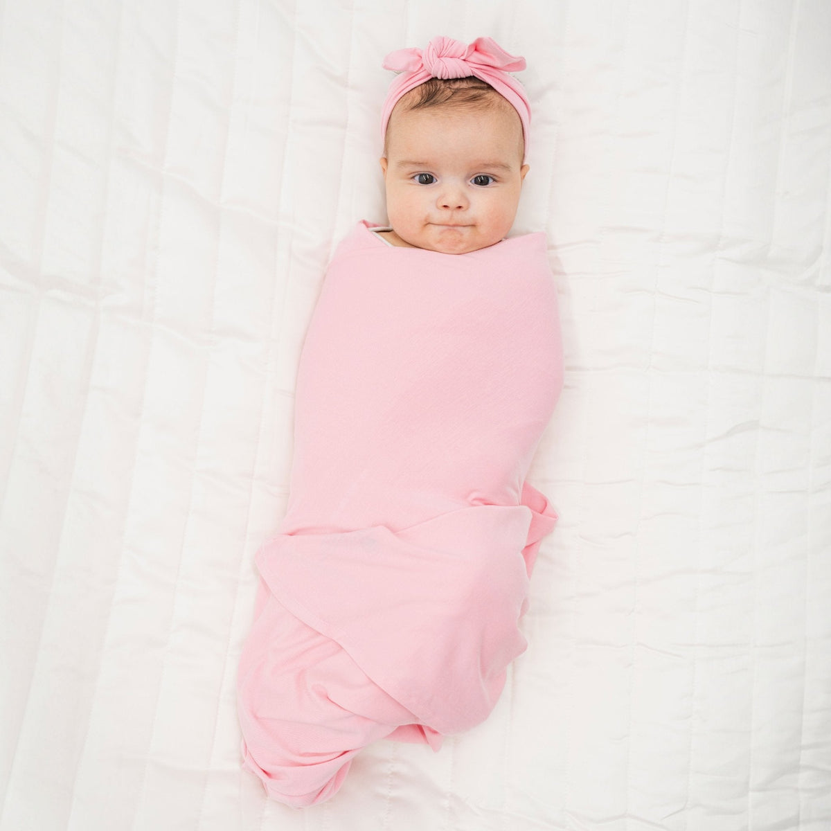 Baby wrapped in Bam & Stitch Pink Blossom Swaddle.