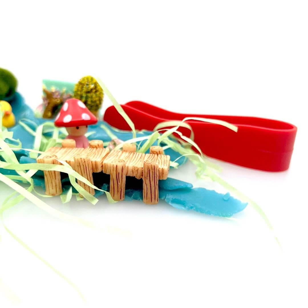 Miniature bridge and red mushroom beside the Pixie Hollow playdough stream