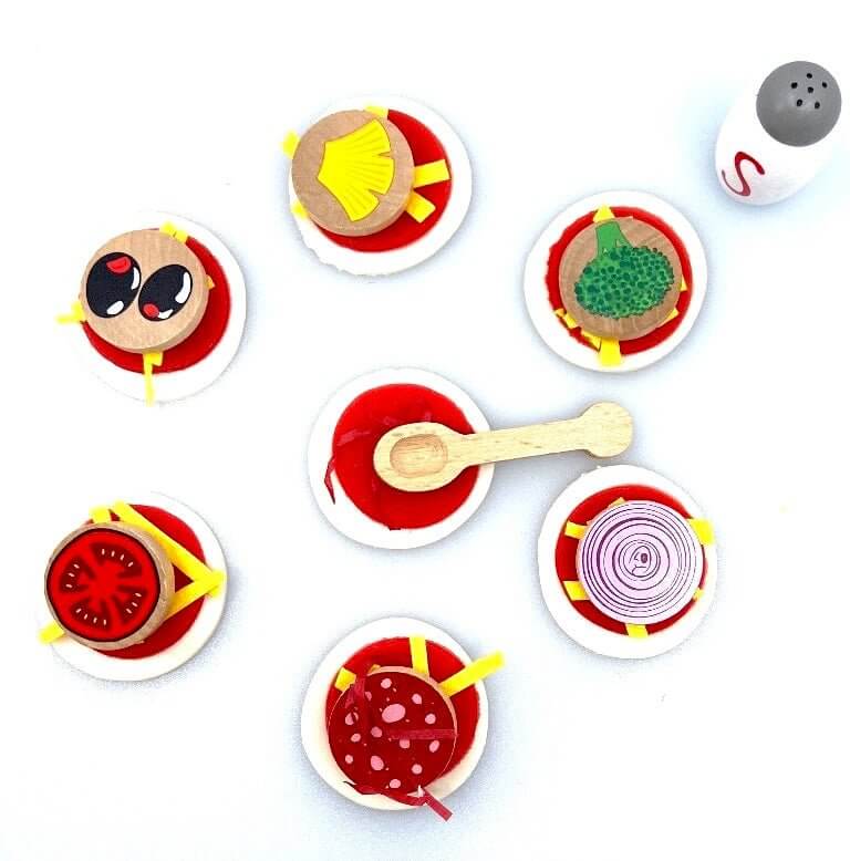 Overhead view of Pizza Bites playdough pizzas with illustrated topping discs