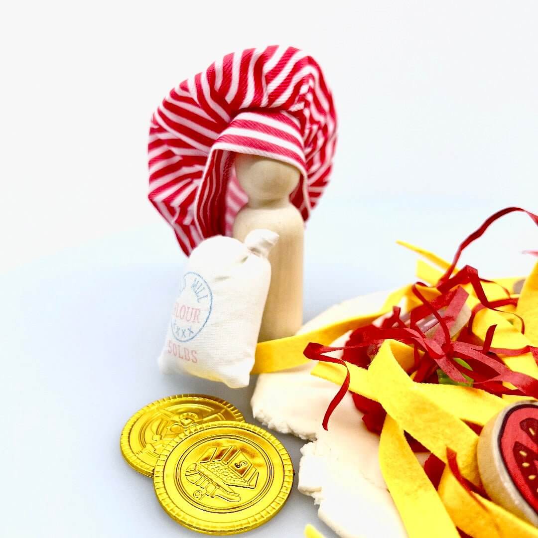 Chef peg figure in a striped hat beside a miniature flour bag and gold-colored play coins