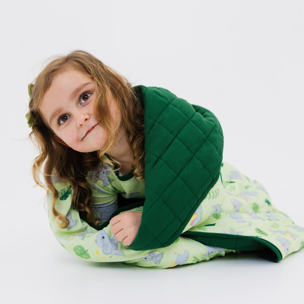 Child seated with Bam & Stitch Playfully Strong Blanket wrapped around them.