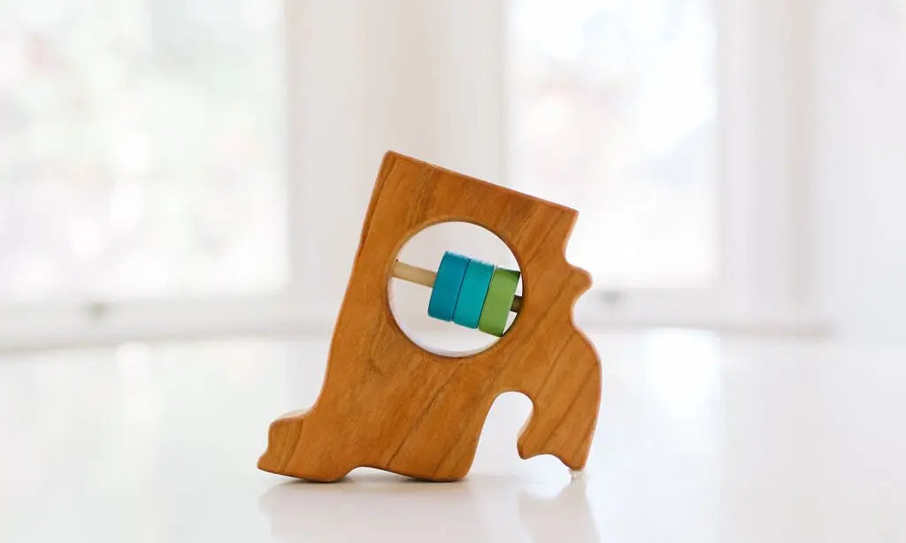 Bannor Toys Rhode Island State Wooden Baby Rattle, showing state-shaped cherry-wood body and colored rattle discs