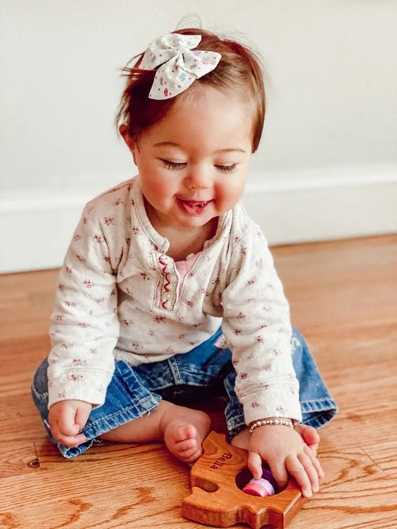 Lifestyle photo showing a wooden state rattle with a child