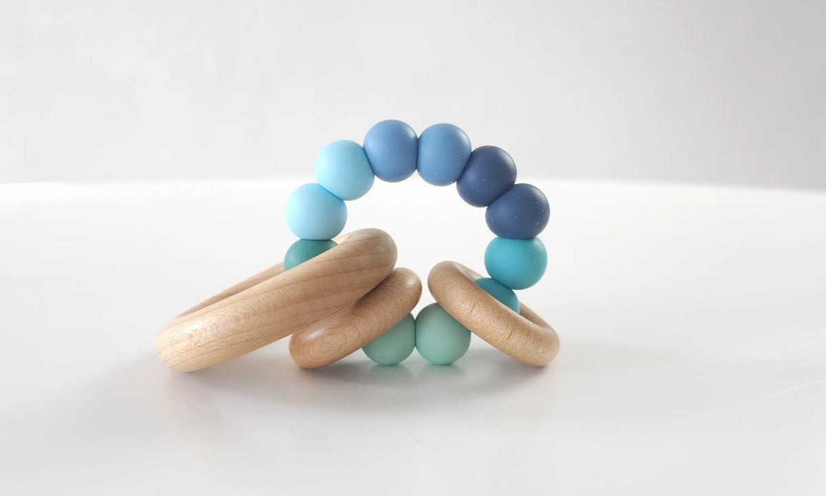 Saturn Ring Teether with blue and green silicone beads and wooden rings
